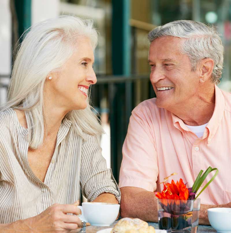 Older couple having a conversation at the table.